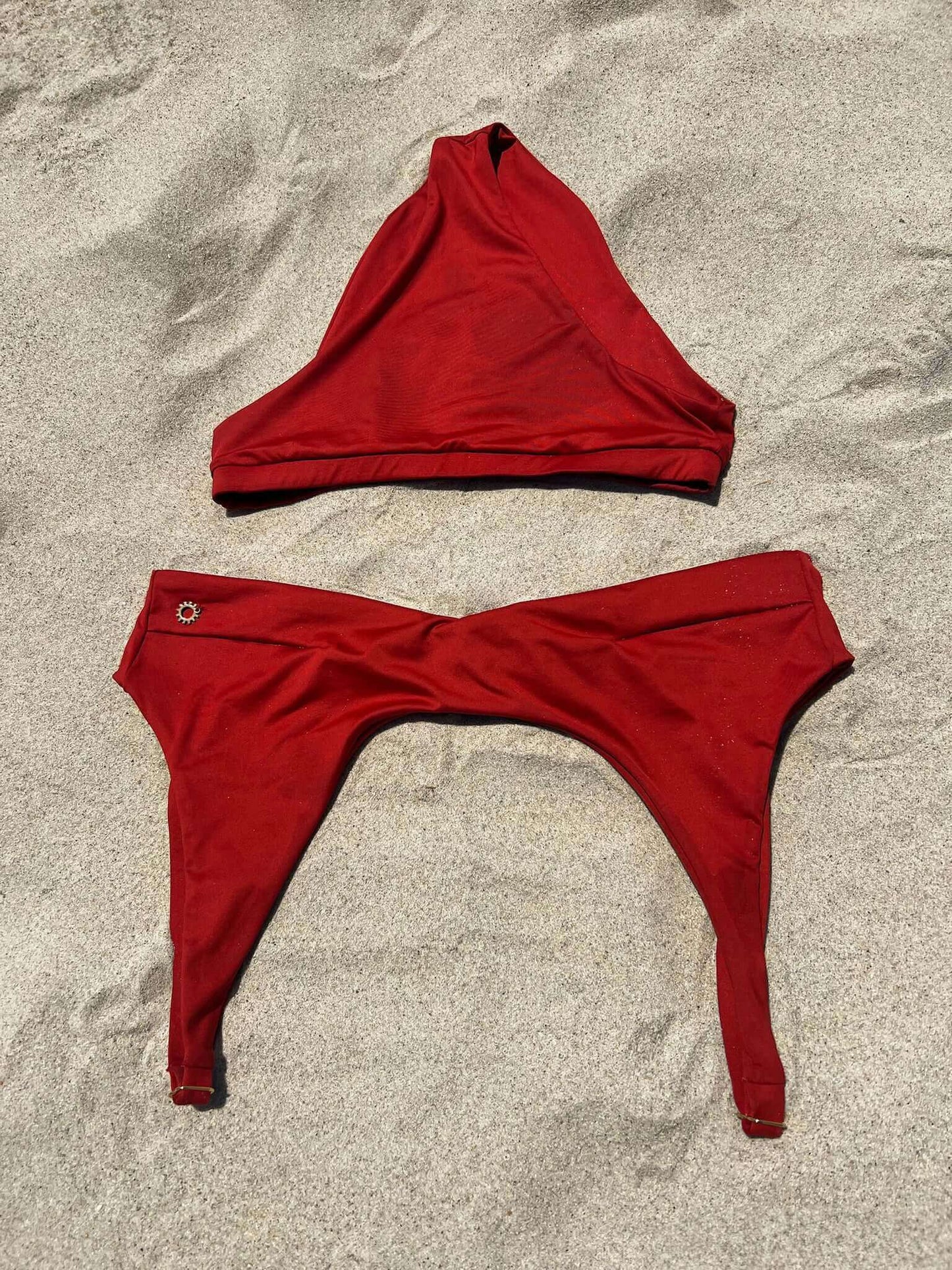 Rosalia Sporty Bikini Top in Rust Red, featuring adjustable straps and quick-drying Bahia fabric on sandy beach.